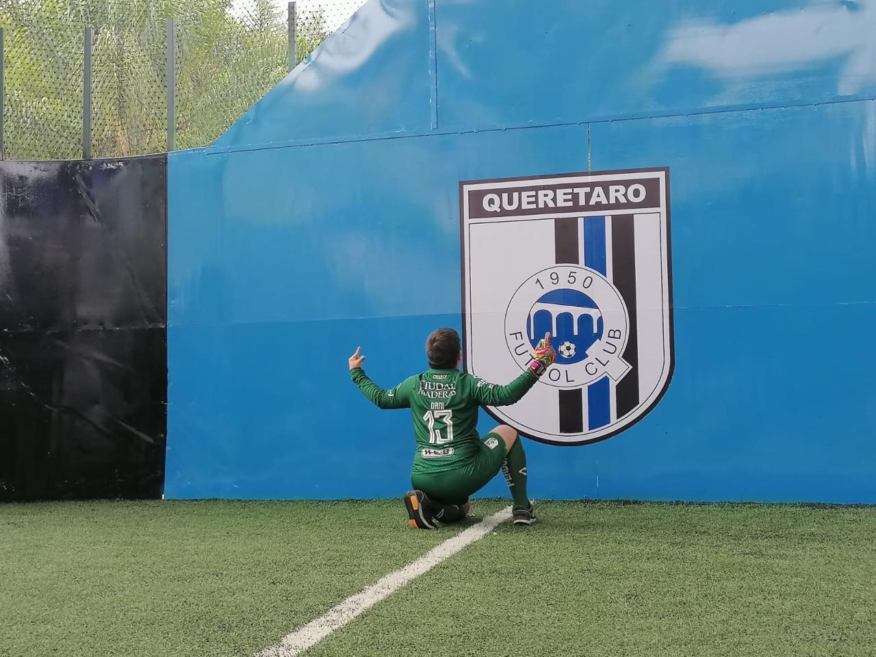 Portero festejando frente al escudo de Querétaro