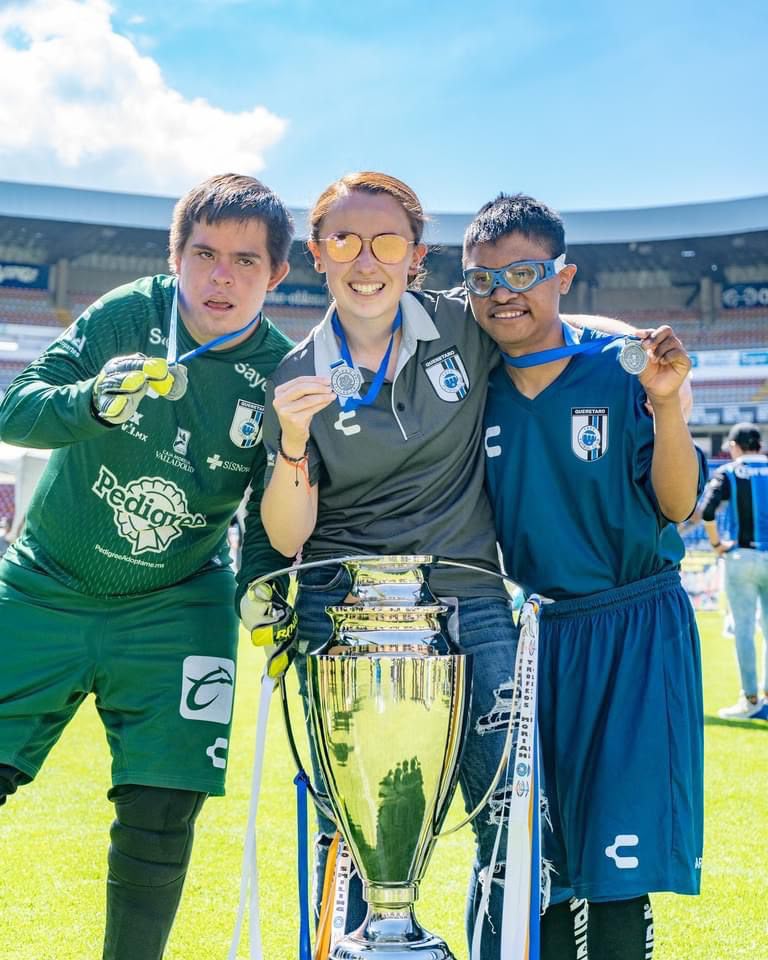 Jugadores de Gallos Smiling con medallas y trofeo de campeones